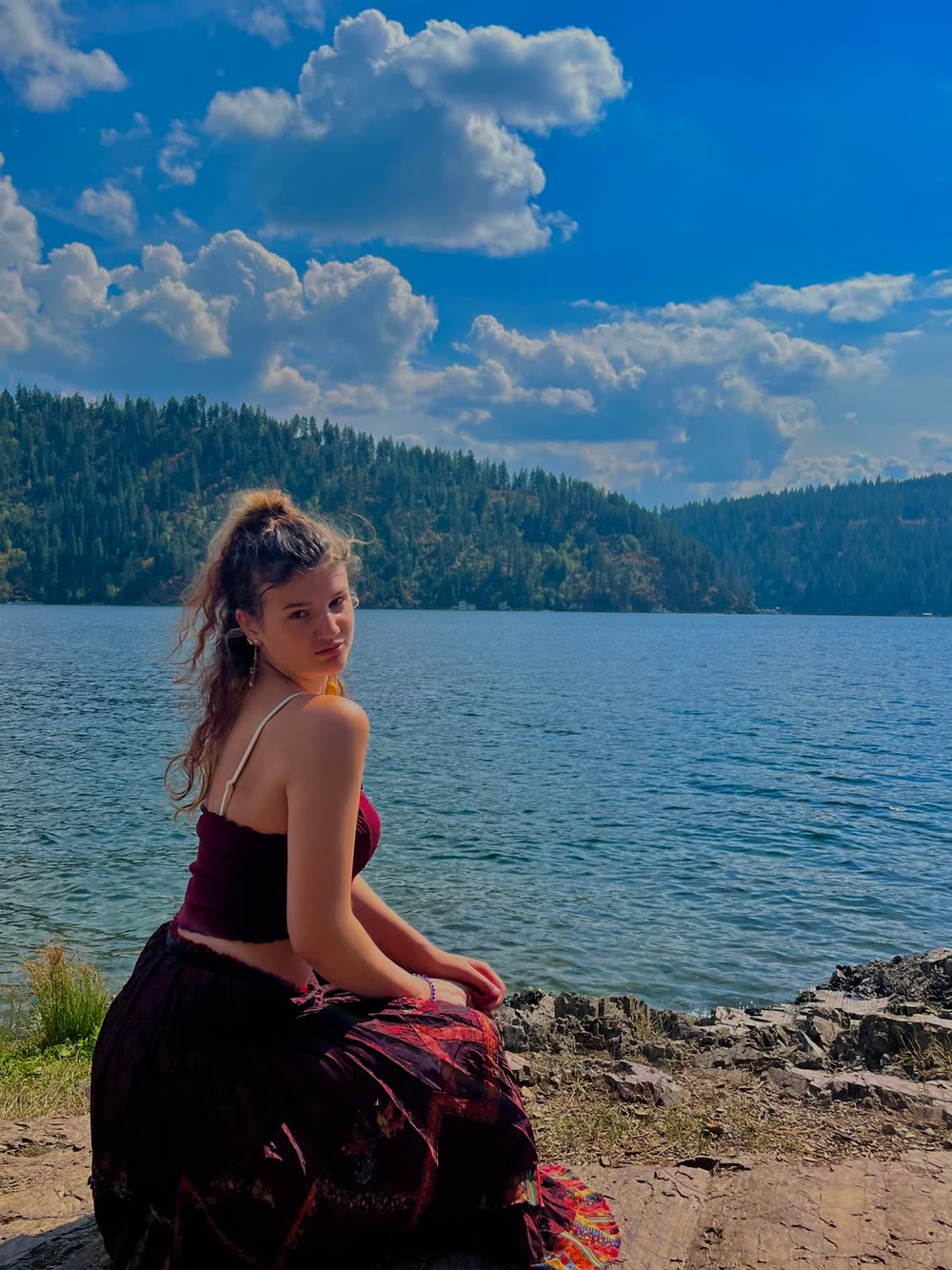 Lilla sitting by a lake under blue skies